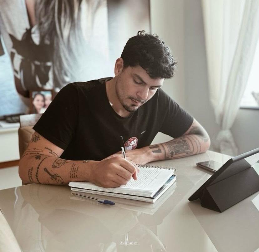Kayo, idealizador da Divide Comigo, escrevendo em um caderno